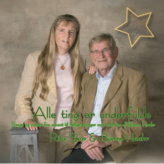 JuleCDen "Alle ting er underfulde" - Rita Skov stående med en hånd på skulderen af Bjarne Haahr, der sidder